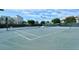 Community tennis court surrounded by lush landscaping and trees at 1945 Gulf Of Mexico Dr # M2-310, Longboat Key, FL 34228