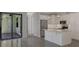 Modern white kitchen with island, stainless steel appliances, and patio access at 906 E Venice Ave, Venice, FL 34285