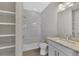 Clean bathroom with built-in shelving, bathtub and granite vanity at 906 E Venice Ave, Venice, FL 34285