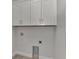 Laundry room with white cabinets and built-in shelving at 906 E Venice Ave, Venice, FL 34285