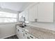 Modern kitchen features white shaker cabinets, granite countertops, and black hardware at 403 Pinewood Ave, Nokomis, FL 34275