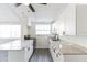 Updated kitchen with white cabinets, granite countertops, and an open layout at 403 Pinewood Ave, Nokomis, FL 34275