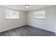 Well-lit bedroom with new flooring and two windows at 403 Pinewood Ave, Nokomis, FL 34275