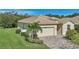 One-story house with a two-car garage, palm trees, and manicured lawn at 1480 Mossy Oak Dr, North Port, FL 34287