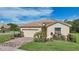 Tan one-story house with a two-car garage and landscaped yard at 1480 Mossy Oak Dr, North Port, FL 34287