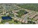Aerial view of a community with houses, a lake, and green spaces at 1480 Mossy Oak Dr, North Port, FL 34287