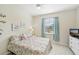 Bright bedroom with a floral-patterned bed and a TV at 1480 Mossy Oak Dr, North Port, FL 34287