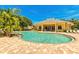 Community pool with a clubhouse and lounge chairs at 1480 Mossy Oak Dr, North Port, FL 34287