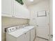 Laundry room with washer, dryer, and cabinets at 1480 Mossy Oak Dr, North Port, FL 34287