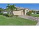 One-story home with attached garage, palm trees, and brick driveway at 1480 Mossy Oak Dr, North Port, FL 34287