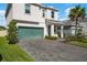 Two-story home with green garage door and landscaped yard at 5873 Bungalow Grove Ct, Palmetto, FL 34221