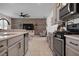 Open kitchen with island, stainless steel appliances, and wood feature wall at 5873 Bungalow Grove Ct, Palmetto, FL 34221