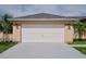 Attached garage with double door and light-grey concrete driveway at 13592 Clara Ln, Port Charlotte, FL 33981