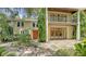 Two-story house with orange door, stone patio, and lush landscaping at 875 Indian Beach Dr, Sarasota, FL 34234