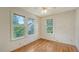 Simple bedroom with wood floors and multiple windows at 875 Indian Beach Dr, Sarasota, FL 34234