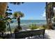 Scenic waterfront view with a bench and palm trees at 875 Indian Beach Dr, Sarasota, FL 34234