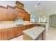 Large kitchen featuring wood cabinets, granite island, and gas cooktop at 6926 73Rd E Ct, Bradenton, FL 34203