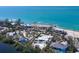 A high-angle aerial view of a luxury beachfront estate, displaying the meticulously landscaped property at 7665 Sanderling Rd, Sarasota, FL 34242