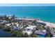An aerial view showcasing a modern home, surrounded by an intricately landscaped yard and pool at 7665 Sanderling Rd, Sarasota, FL 34242