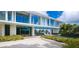 Expansive modern home featuring walls of glass, beautiful landscaping, and an inviting outdoor area with a pool at 7665 Sanderling Rd, Sarasota, FL 34242