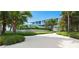 Stately home framed by lush landscaping and palm trees, showcasing a pristine driveway and verdant lawn at 7665 Sanderling Rd, Sarasota, FL 34242