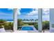 Stunning ocean view from the property's deck, framing a serene scene of palm trees and a blue sky backdrop at 7665 Sanderling Rd, Sarasota, FL 34242