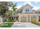 Tan two-story townhome with two-car garage, landscaping, and walkway at 7922 Tybee Ct, University Park, FL 34201
