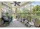 Cozy screened porch with patio furniture and ceiling fan, overlooking lush greenery at 7922 Tybee Ct, University Park, FL 34201