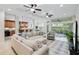 Open living room with sectional sofa, kitchen view, and access to patio at 7922 Tybee Ct, University Park, FL 34201
