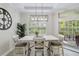 Bright dining room features a table with four chairs, a large clock, and access to a patio at 7922 Tybee Ct, University Park, FL 34201