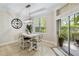 Bright dining room features a table with four chairs, a large clock, and access to a patio at 7922 Tybee Ct, University Park, FL 34201