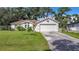 Single story house featuring a white exterior, attached garage, and green lawn at 2843 Abbotsford St, North Port, FL 34287