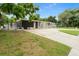 Mid-century modern home with landscaped yard and carport at 2015 Bayshore Gardens Pkwy, Bradenton, FL 34207