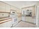 Kitchen with white appliances, light cabinets, and pass-through to dining area at 2708 60Th Avenue W Ter # A, Bradenton, FL 34207