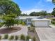 Charming home with a metal roof, lush landscaping, and a circular gravel driveway at 5307 2Nd Avenue Nw Dr, Bradenton, FL 34209