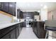 Modern kitchen with dark cabinetry, stainless steel appliances and an island at 11721 Brighton Knoll Loop, Riverview, FL 33579