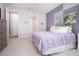 Well-lit bedroom with plush lavender bedding and access to bath at 11721 Brighton Knoll Loop, Riverview, FL 33579