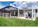 Screened pool and patio area with fire pit and string lights at 11721 Brighton Knoll Loop, Riverview, FL 33579