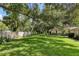 Large grassy backyard with mature trees and privacy fence at 3541 Wilkinson Woods Dr # 40, Sarasota, FL 34231
