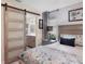Main bedroom with a king-size bed, barn door to bathroom, and updated flooring at 3541 Wilkinson Woods Dr # 40, Sarasota, FL 34231