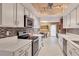 Galley kitchen features white cabinetry, stainless appliances, stone countertops and stylish backsplash at 3541 Wilkinson Woods Dr # 40, Sarasota, FL 34231