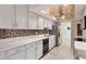 Bright kitchen featuring white cabinetry, stone countertops, tile backsplash, stainless dishwasher and lighting at 3541 Wilkinson Woods Dr # 40, Sarasota, FL 34231