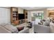 Bright living room features wood entertainment center, neutral walls, stylish furniture and sliding doors to lanai at 3541 Wilkinson Woods Dr # 40, Sarasota, FL 34231