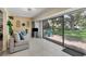 Bright Florida room with neutral walls, stylish furniture, decorative wall hangings and large glass doors to patio at 3541 Wilkinson Woods Dr # 40, Sarasota, FL 34231