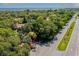 Scenic aerial view of lush landscaping, winding roads, and beautiful homes near the water at 3601 Quail Hollow Ln, Bradenton, FL 34210