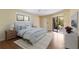 This staged bedroom offers wood floors, a ceiling fan, and a screened lanai at 3601 Quail Hollow Ln, Bradenton, FL 34210