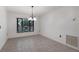 A spacious dining area with tiled floors and a chandelier fixture, next to a large window at 3601 Quail Hollow Ln, Bradenton, FL 34210