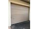 Closed, light brown garage door in a home's facade, providing secure and private parking at 3601 Quail Hollow Ln, Bradenton, FL 34210