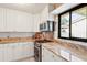 Well-maintained kitchen with stainless steel appliances, granite countertops, and white cabinetry at 3601 Quail Hollow Ln, Bradenton, FL 34210