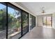 This empty lanai offers floor to ceiling windows overlooking lush landscaping and a pond at 3601 Quail Hollow Ln, Bradenton, FL 34210
